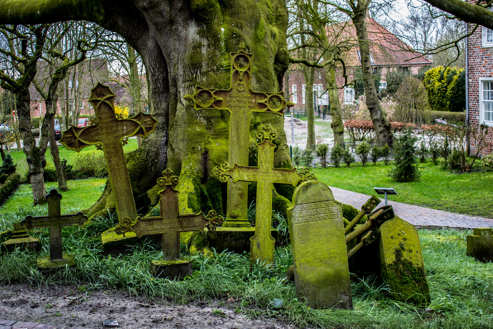 Ausrangierte Grabsteine / Kreuze unter der Friedhofslinde