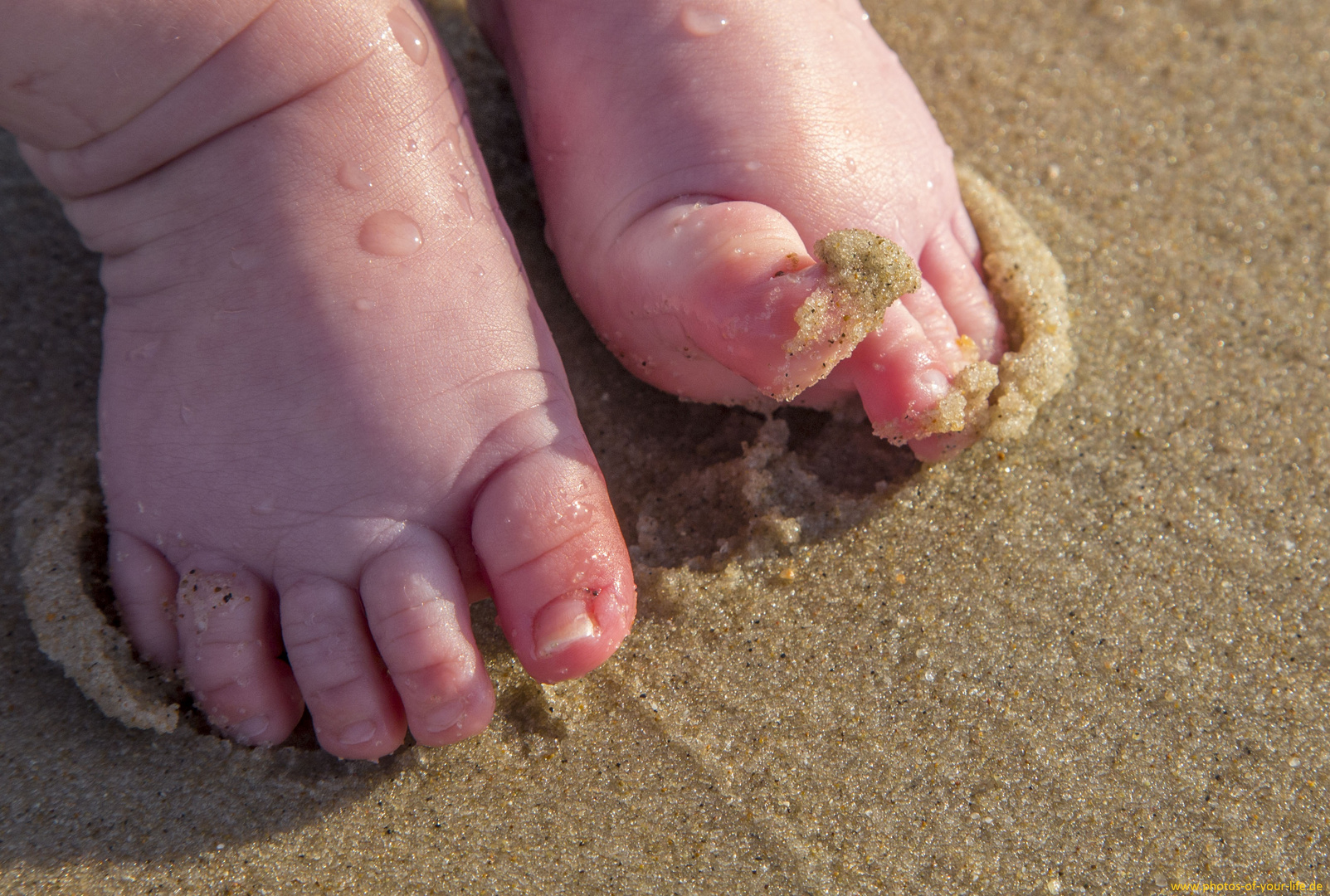 Baby-Füße das erste mal im Sand