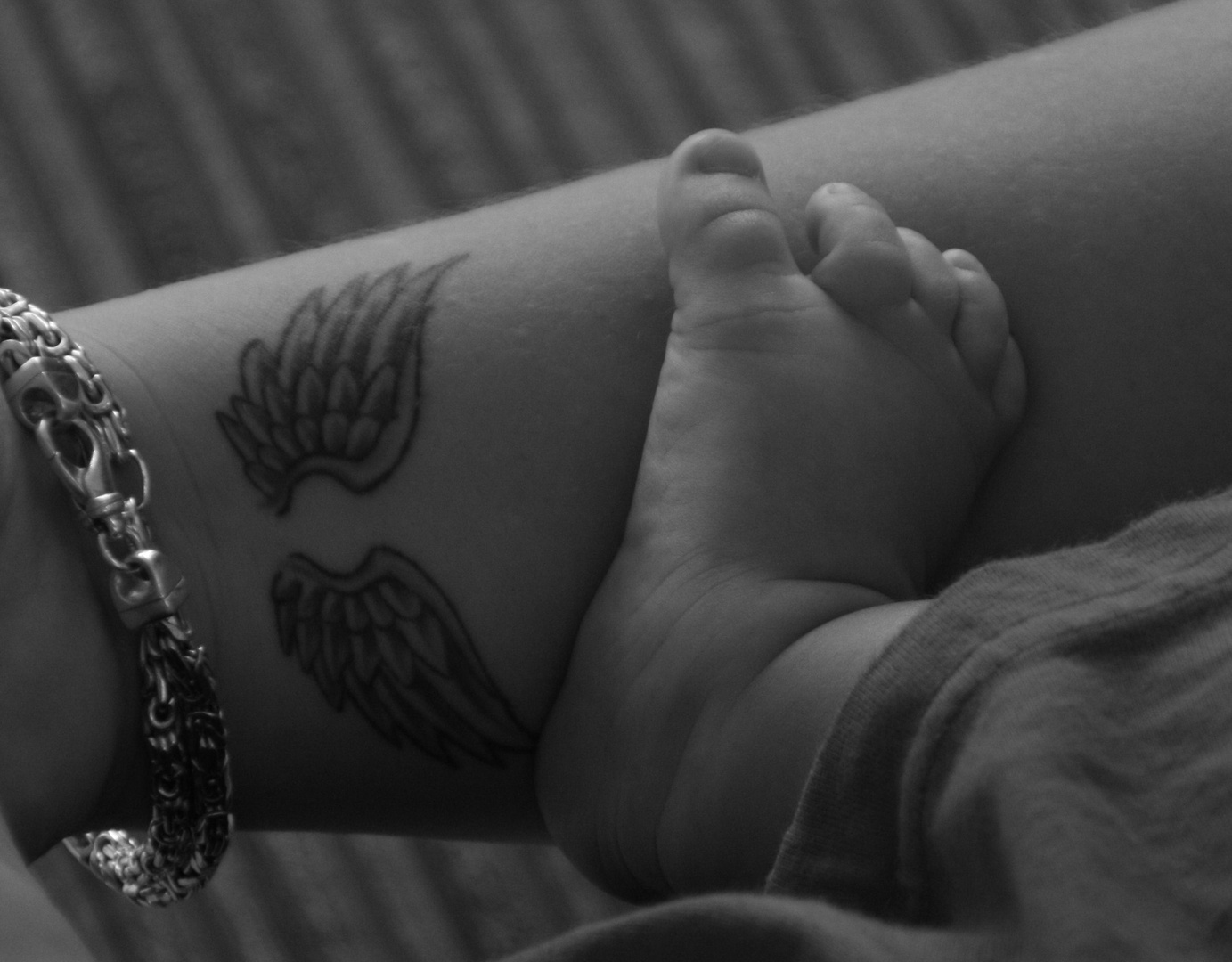Babyfuß auf Tattoowiertem Arm...