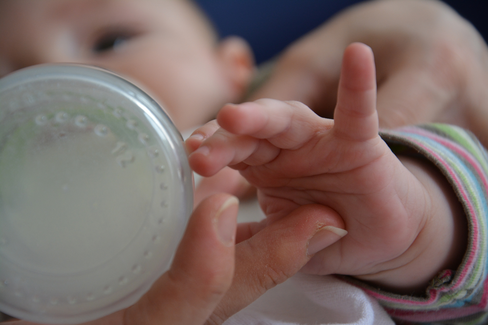 Babyhand und Milchflasche