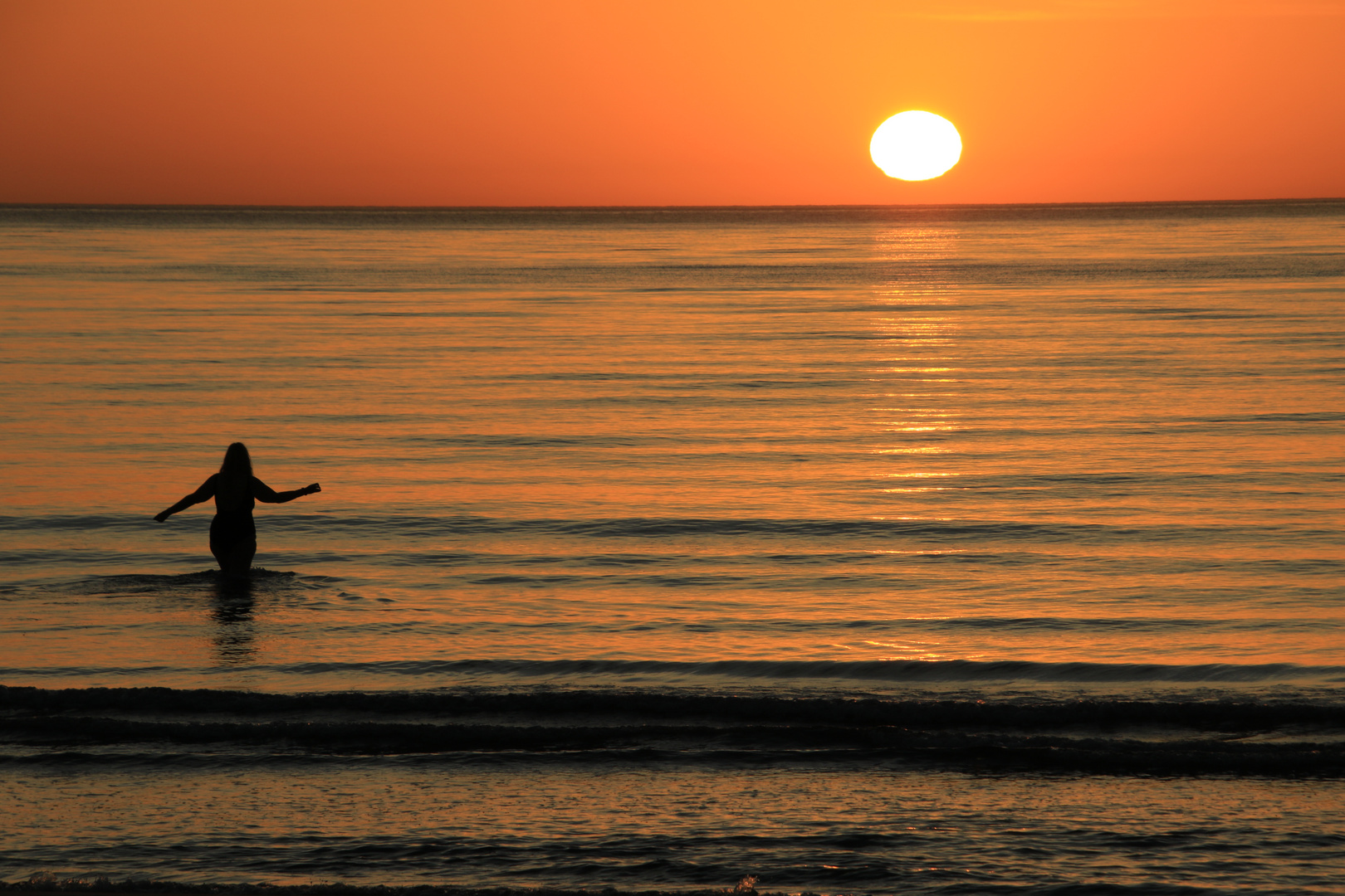 Bad im Meer bei Sonnenaufgang