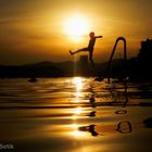 Badende Kinder bei Sonnenuntergang