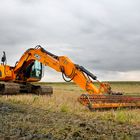 Bagger auf einem Stoppelfeld in Ostfriesland