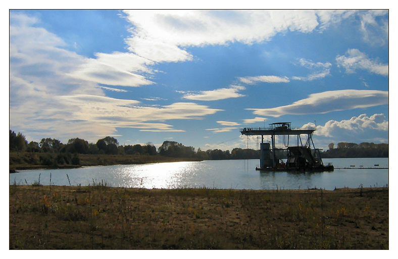 Bagger im See mit blauem Himmel