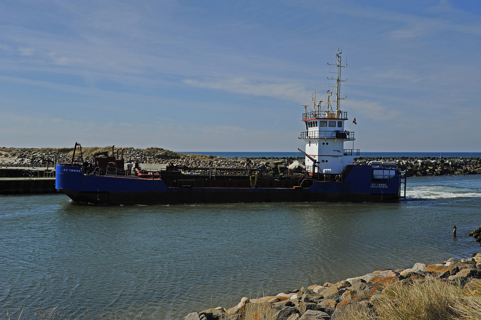 Baggerschiff bei der Einfahrt in den kleinen Hafen von Thorsminde (Midtjylland, DK)