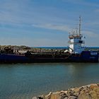 Baggerschiff bei der Einfahrt in den kleinen Hafen von Thorsminde (Midtjylland, DK)