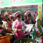 Bai-Maedchen verkaufen Mirabellen auf dem Fruehlingsfestmarkt in Kunming