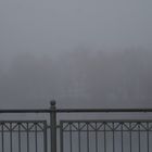 Balustrade im Nebel mit Bäumen im Hintergrund