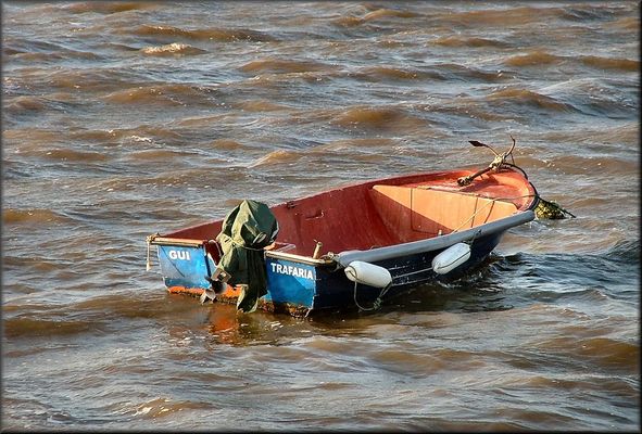 Barca sul fiume Tejo agitato.