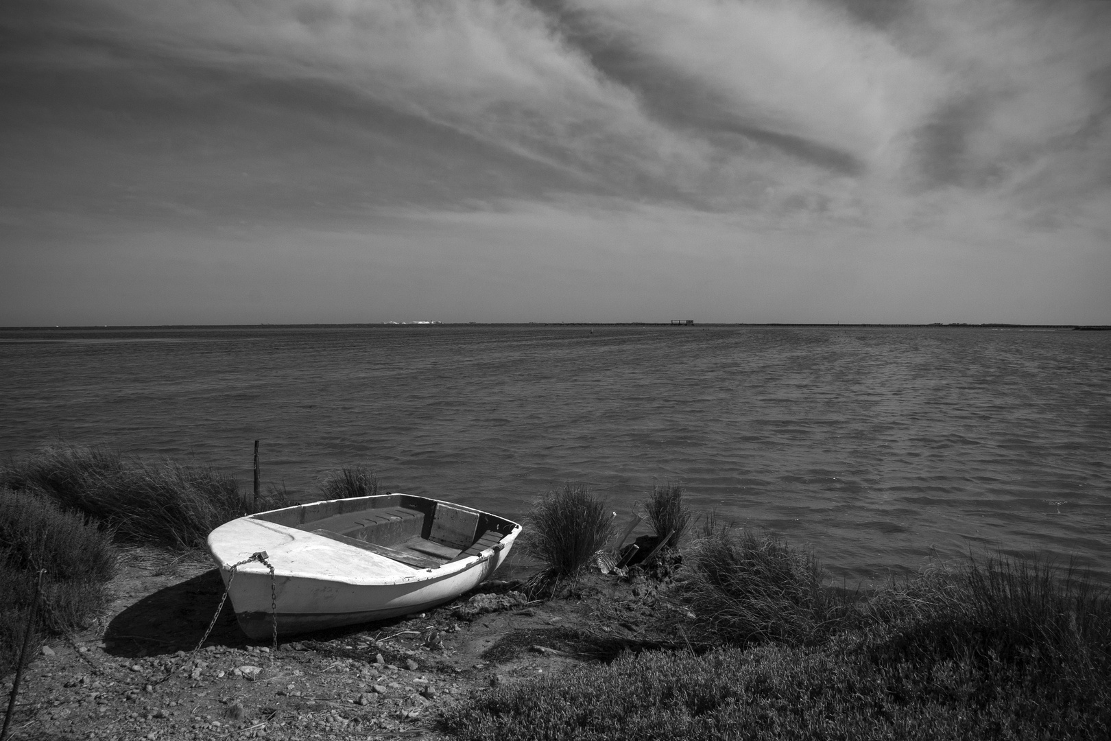 Barca y silla frente a las salinas de la Punta de la Banya