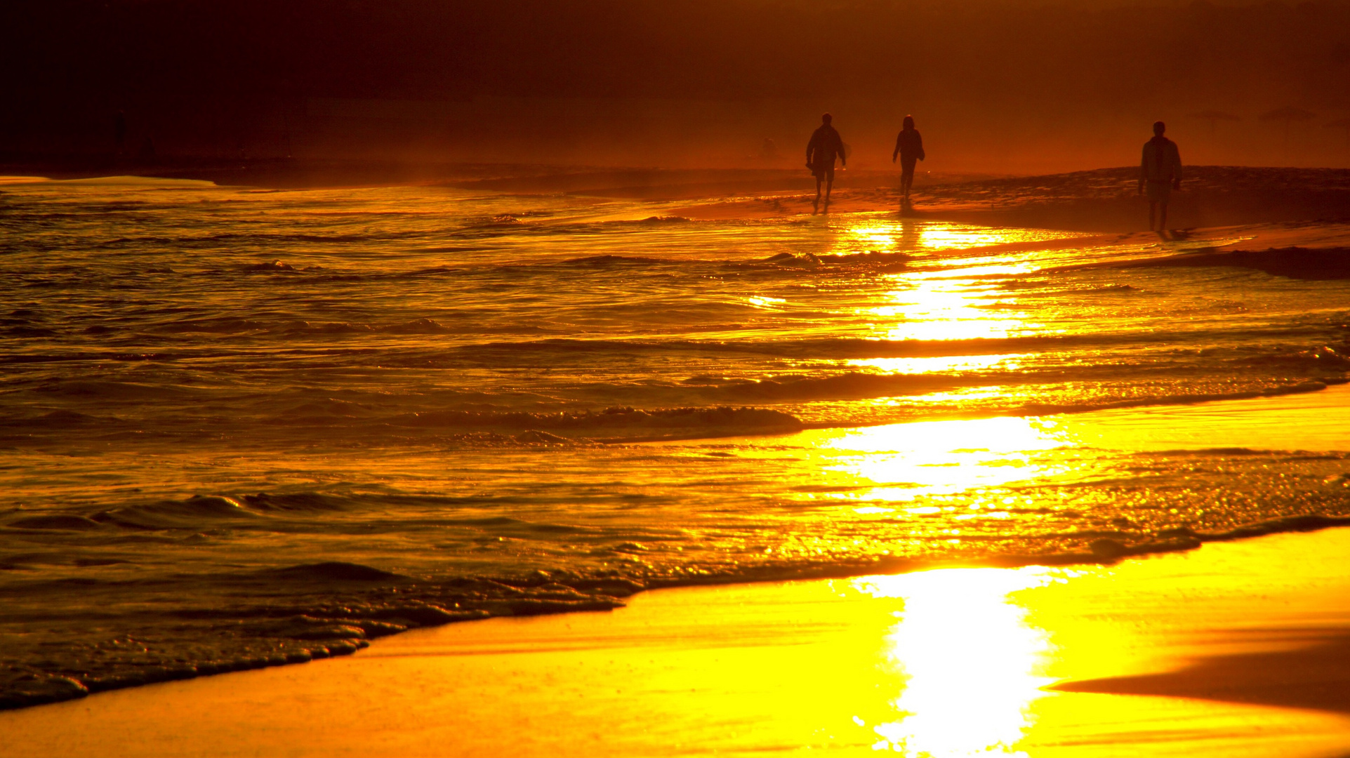 barfuß laufen wir durch Sand und Wasser umgeben von goldenem Sonnenlicht 