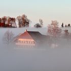 Bauernhaus vom Nebel umhüllt