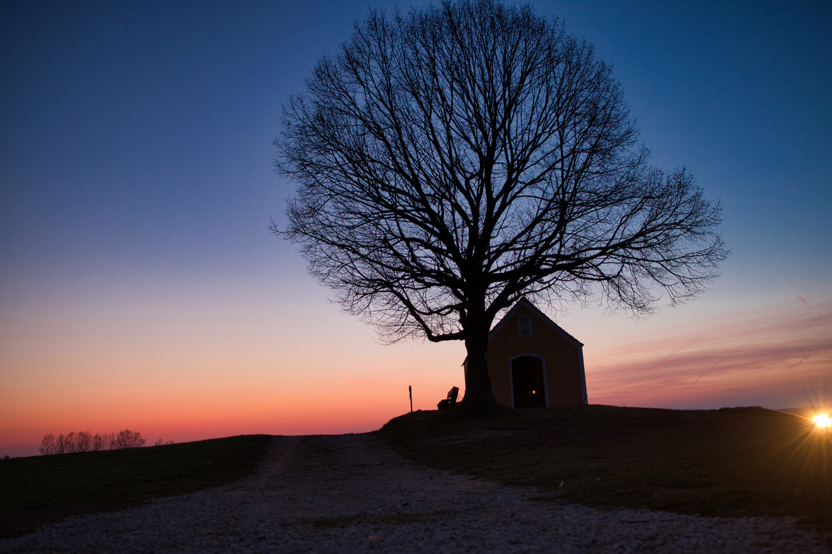 Baum mit kleiner Kapelle oberhalb von Neuhaus