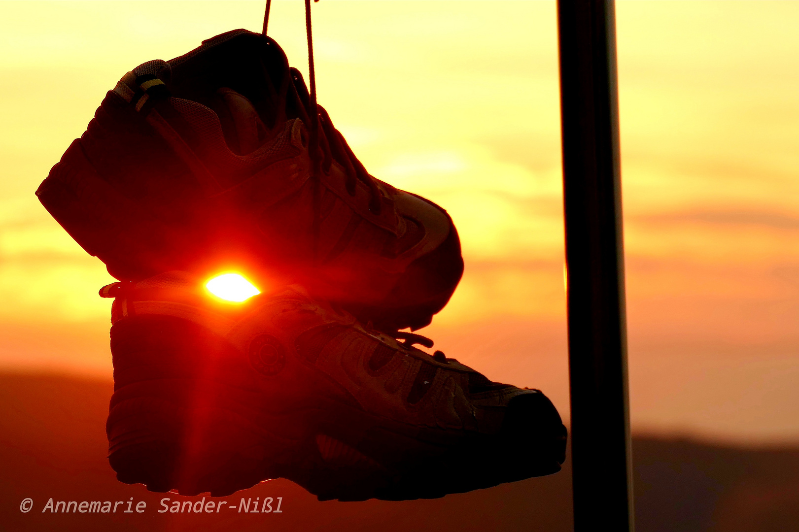 Baumelnde Schuhe im sunset