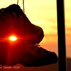 Baumelnde Schuhe im sunset