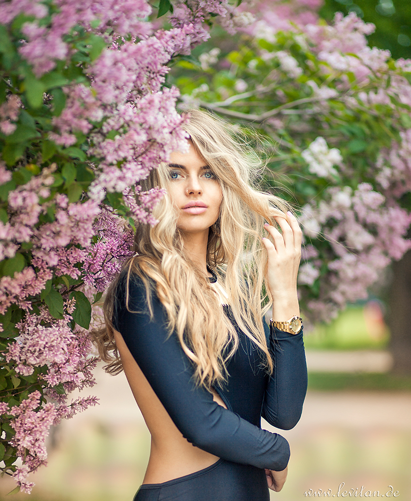 Beautiful woman in the bushes with lilac