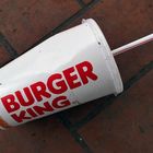 Becher: Der Rot-Weiße von Burger King mit Strohhalm im Stadtpark