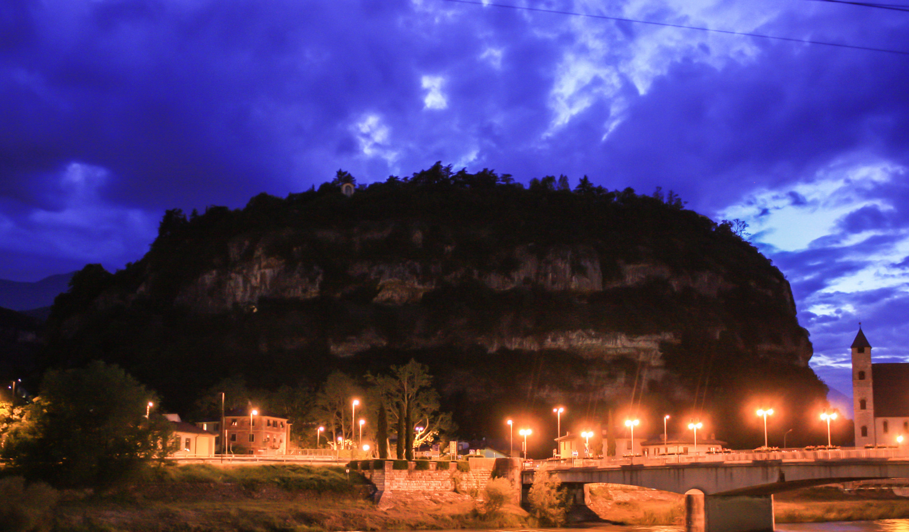 Berg mit Kirche in Trient bei Nacht