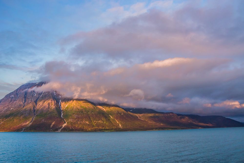 Berg mit Wolken bei tiefstehender Sonne