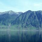 Bergansicht vom Fjord aus mit Spiegelung im Meer