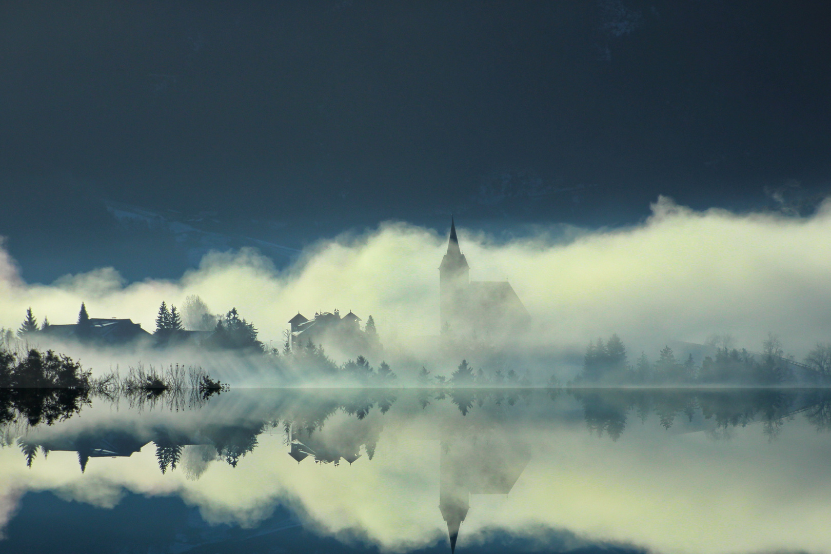 Bergdorf in den Dolomiten im Morgennebel