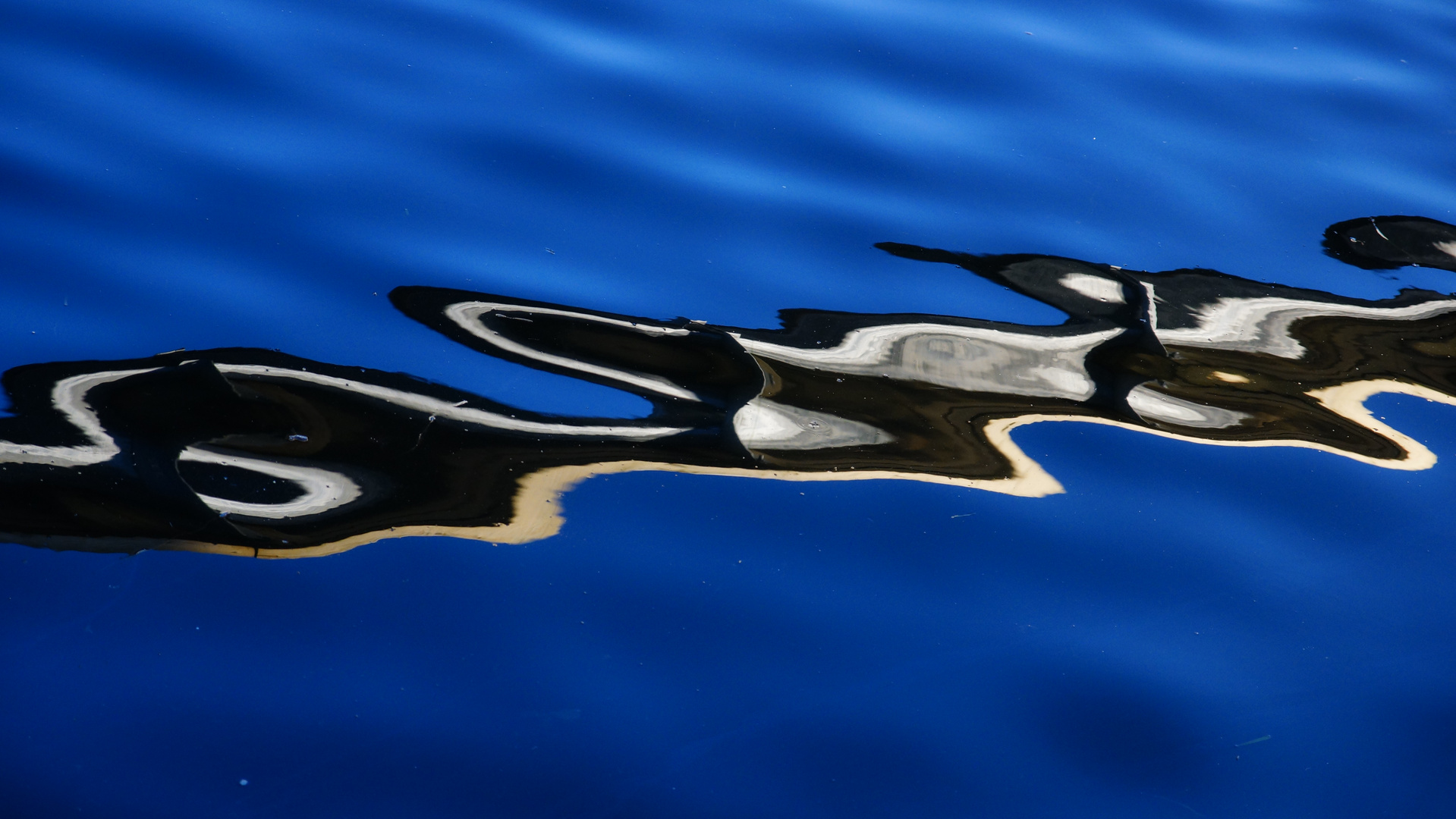 Bewegter Spiegel im himmelblauen Wasser