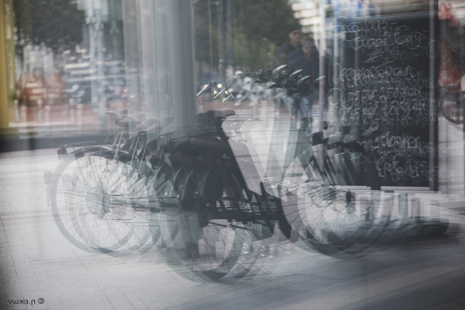 Bicyles mirrored in a Bakery's Door