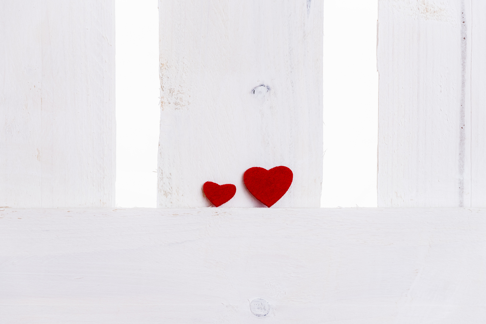 Big and small red hearts on a fence