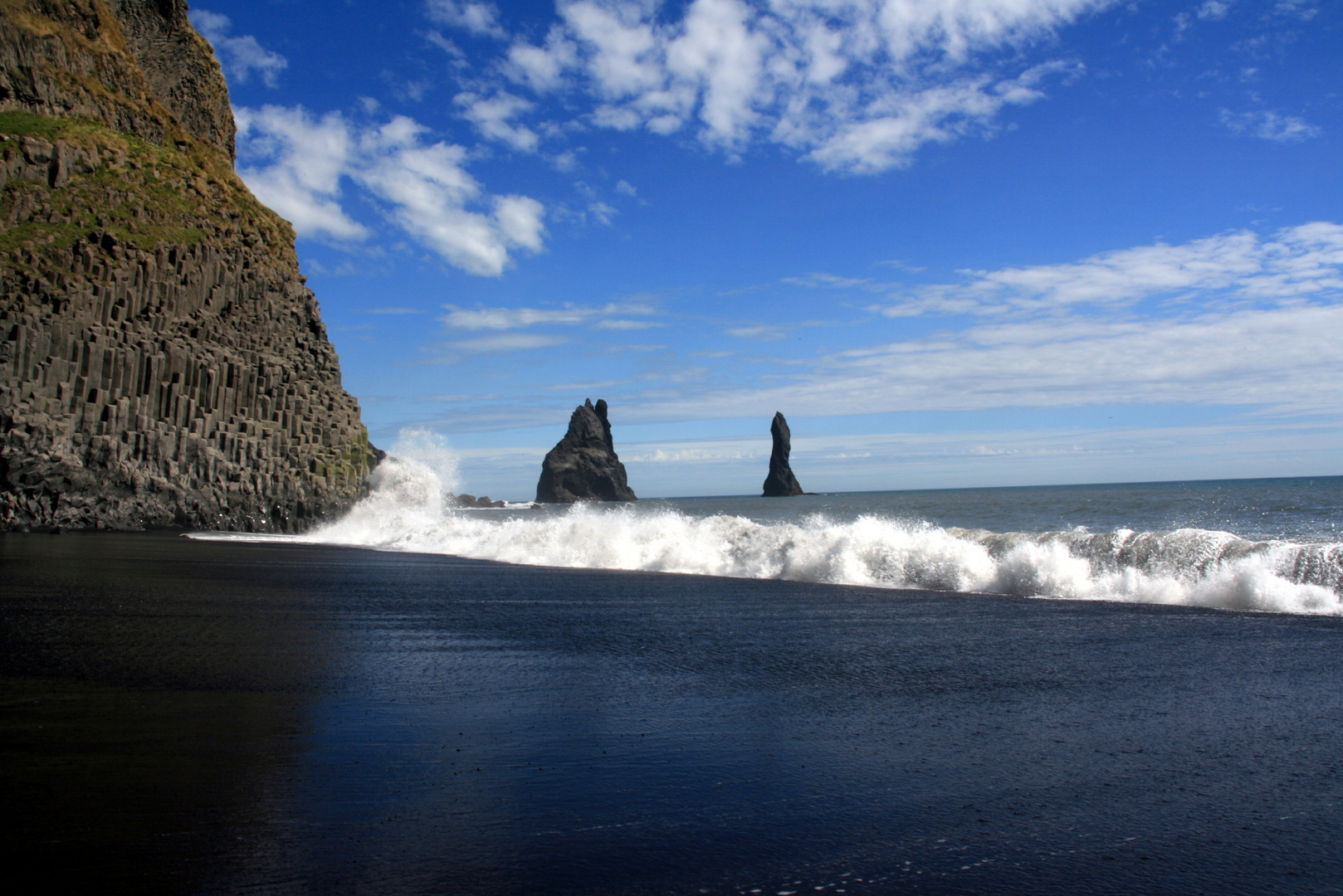 Black beach under blue sky