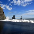 Black beach under blue sky