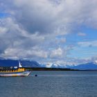 blau gelbes Schiff vor schneebedeckten Bergen