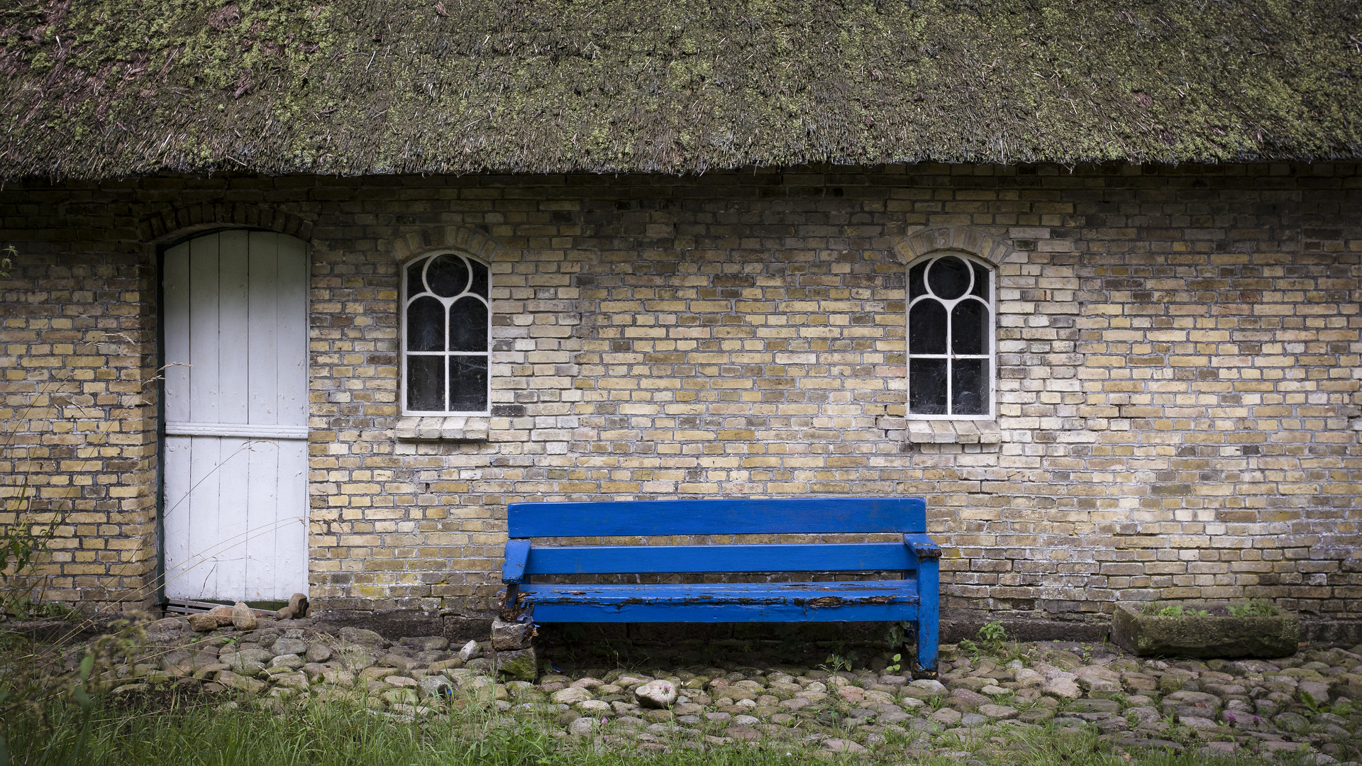 Blaue Bank vor Bauernhaus