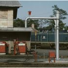 Blaue Diesellok an roter Tankstelle