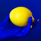 Blaue Hand mit Zitrone