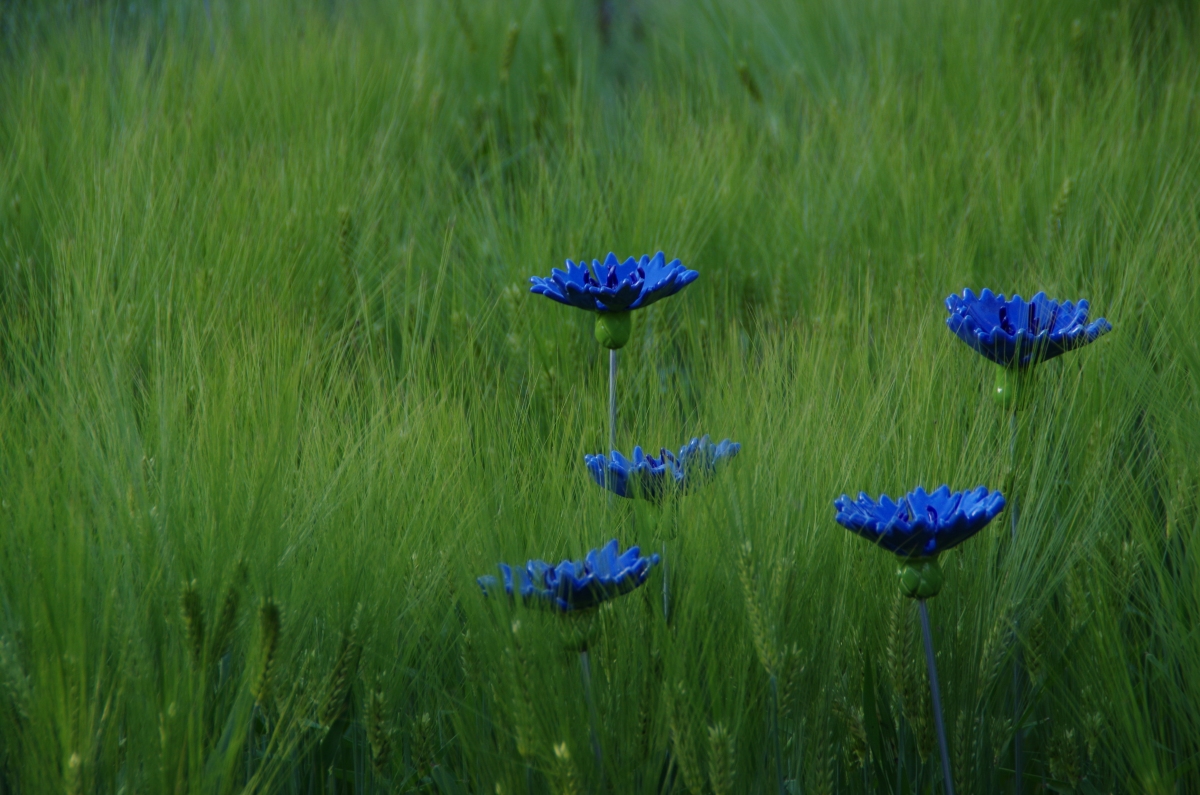 Blaue Kunstblumen im Grünen