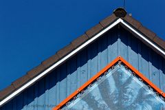 BLAUER GIEBEL MIT PIEPSER UNTER BLAUEM HIMMEL