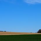 Blauer Himmel über Wald und Felder