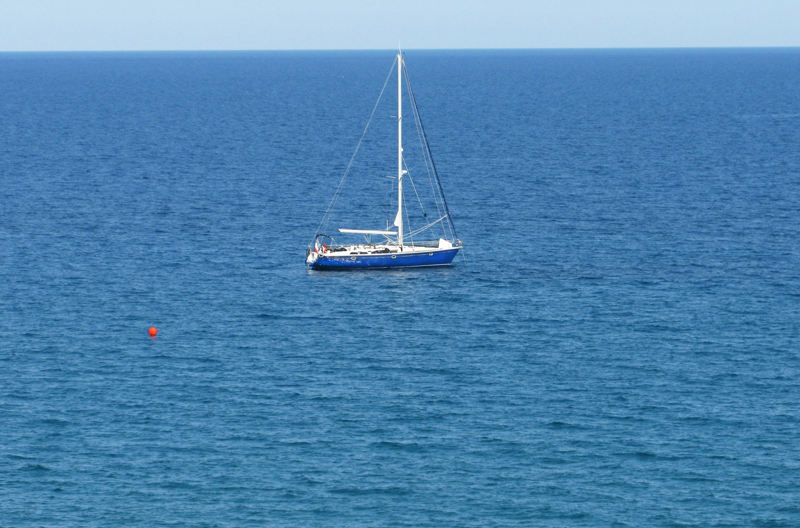 Blaues Boot und rote Boje