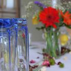 Blaues Glas und rote Blüten