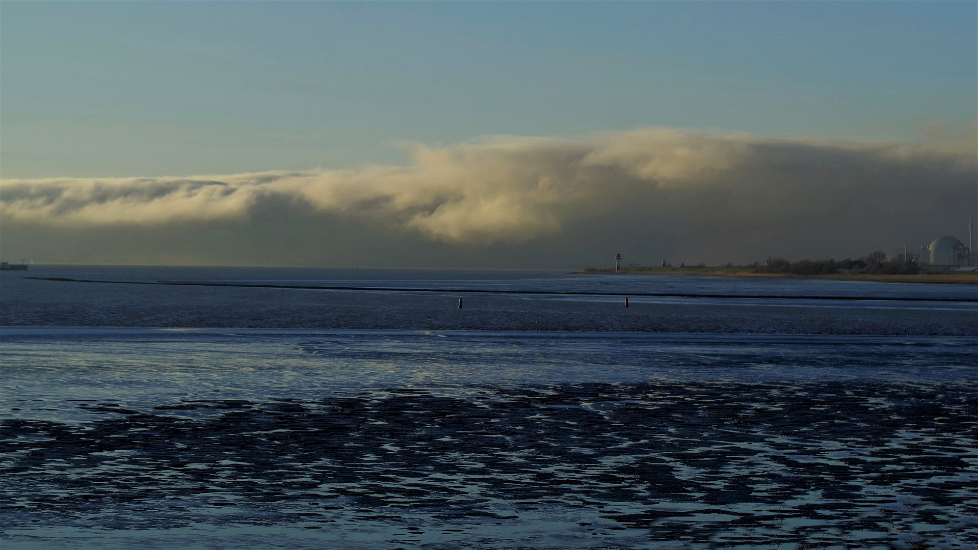 blaues Watt mit gespenstischer Wolkenbank