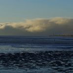 blaues Watt mit gespenstischer Wolkenbank