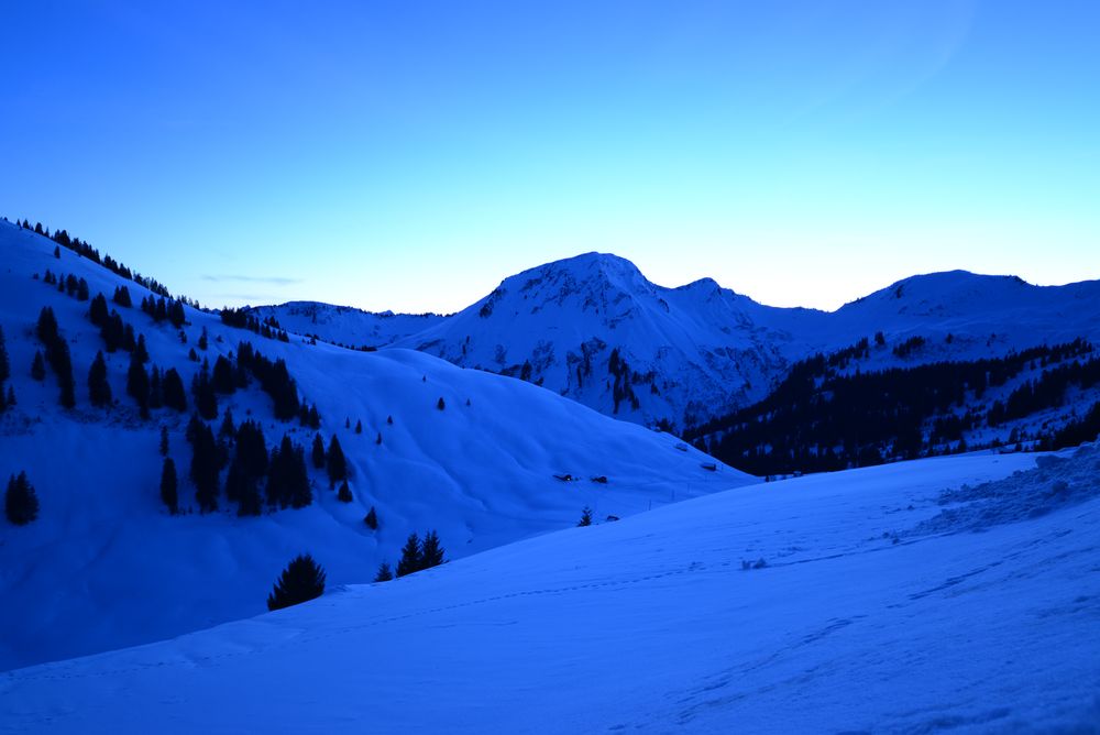 Blaulicht über dem Schnee in den Bergen