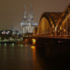 Blick auf den Kölner Dom und die Hohenzollern-Brücke im Winter bei Nacht