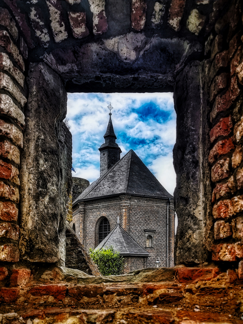 Blick auf die Schlosskapelle Liedberg durch das Gemäuer