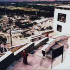 blick auf die treppen zu den gebetsräumen vom kloster thikse und im hintergrund das dorf