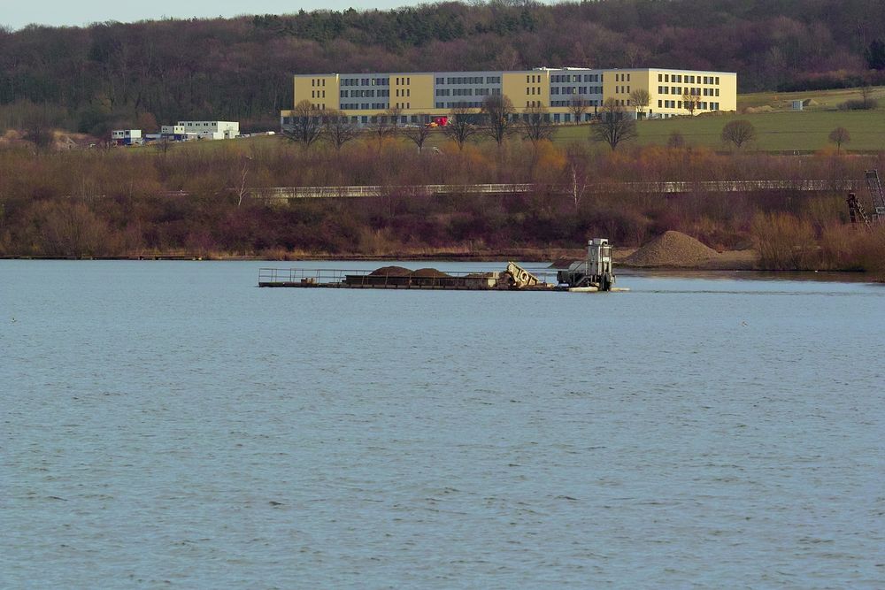 Blick auf Freizeitsee mit Kiesschute und Krankenhausneubau in Northeim.