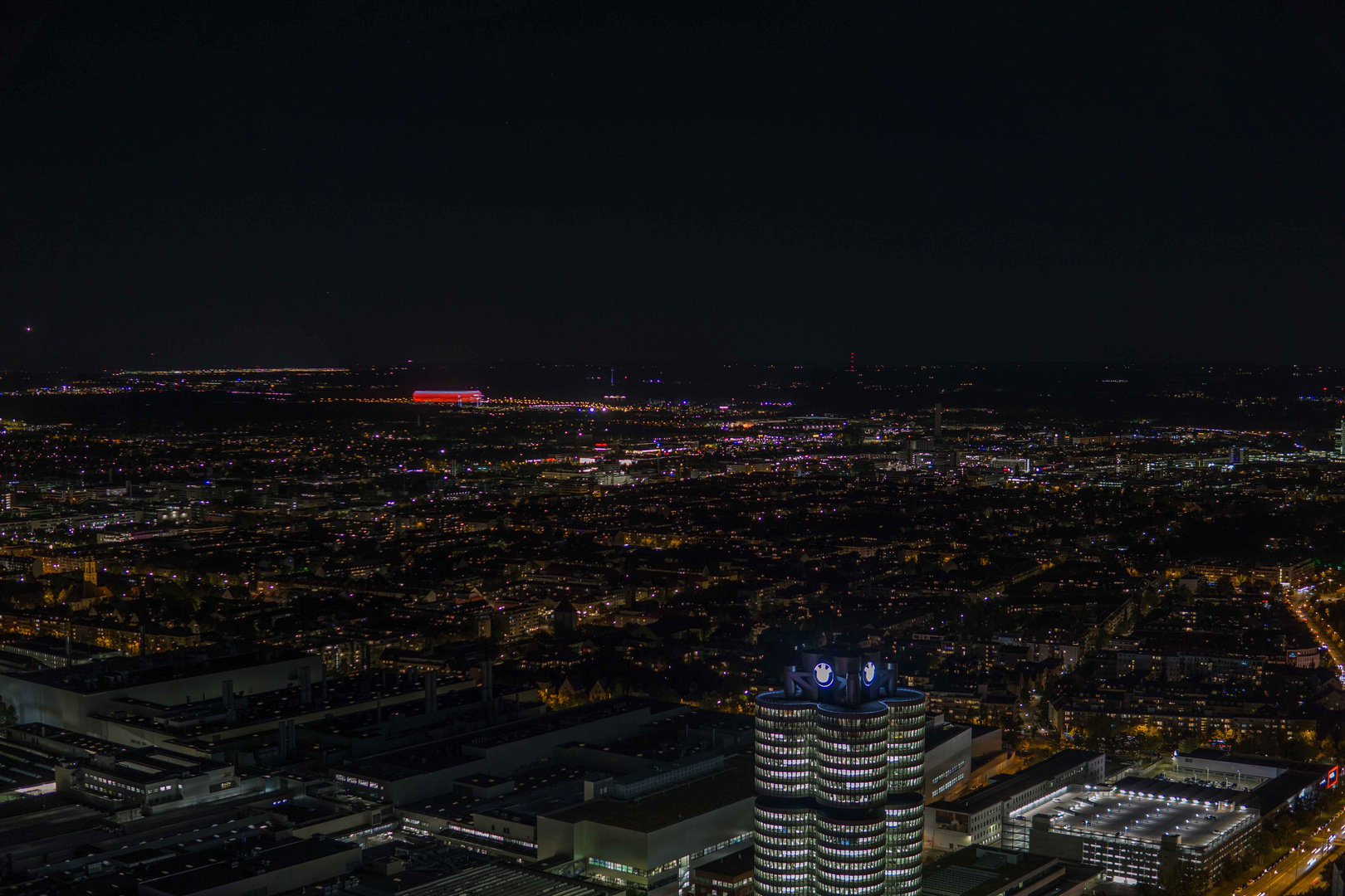 Blick auf München bei Nacht mit BMW und Allianzarena