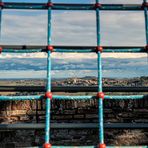 Blick durch ein Kletter-Netz auf einem Spielplatz auf