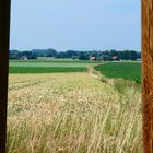 Blick durch einen Strommast auf dem Land