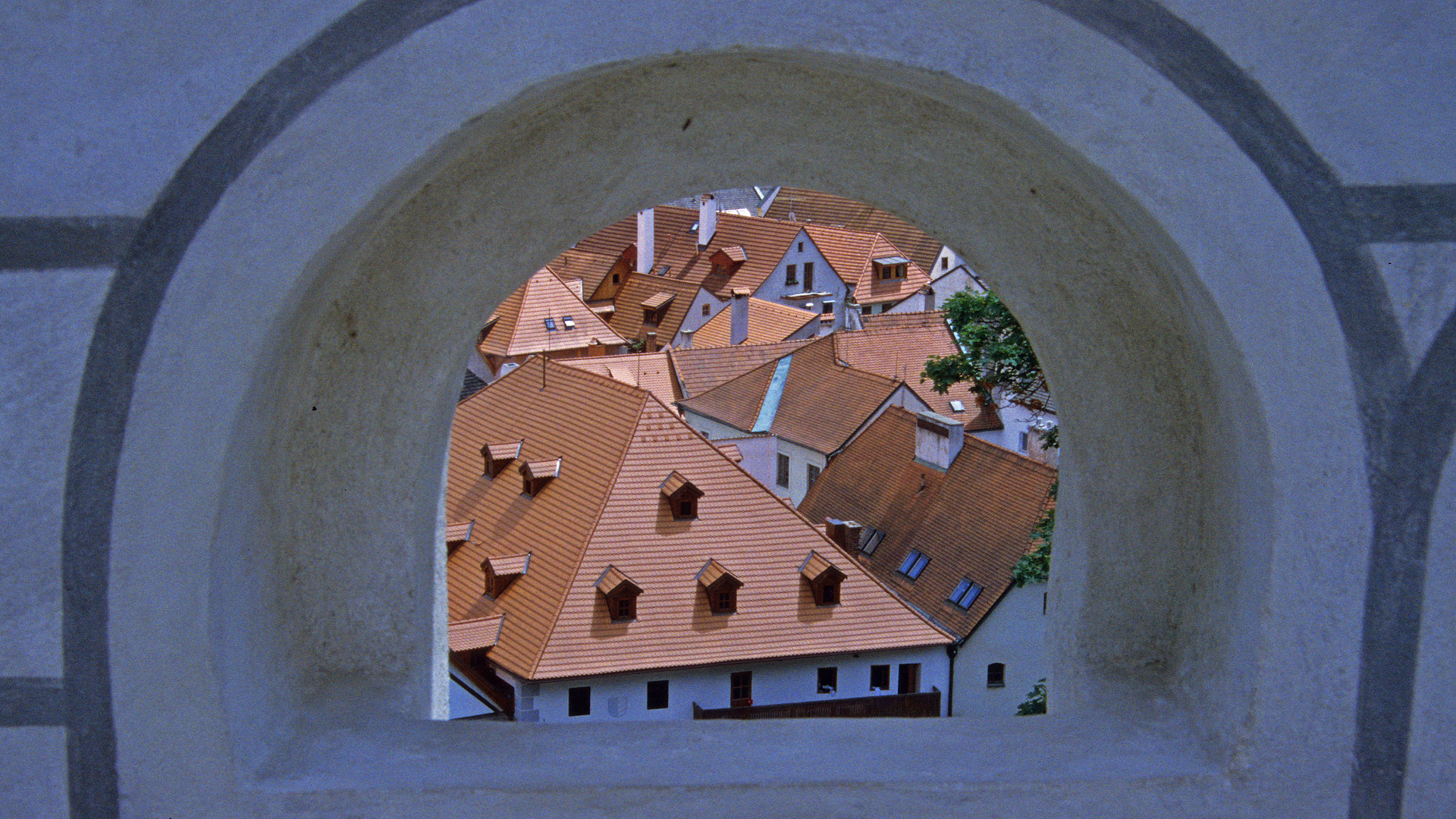 Blick durch Mauer auf Dächer